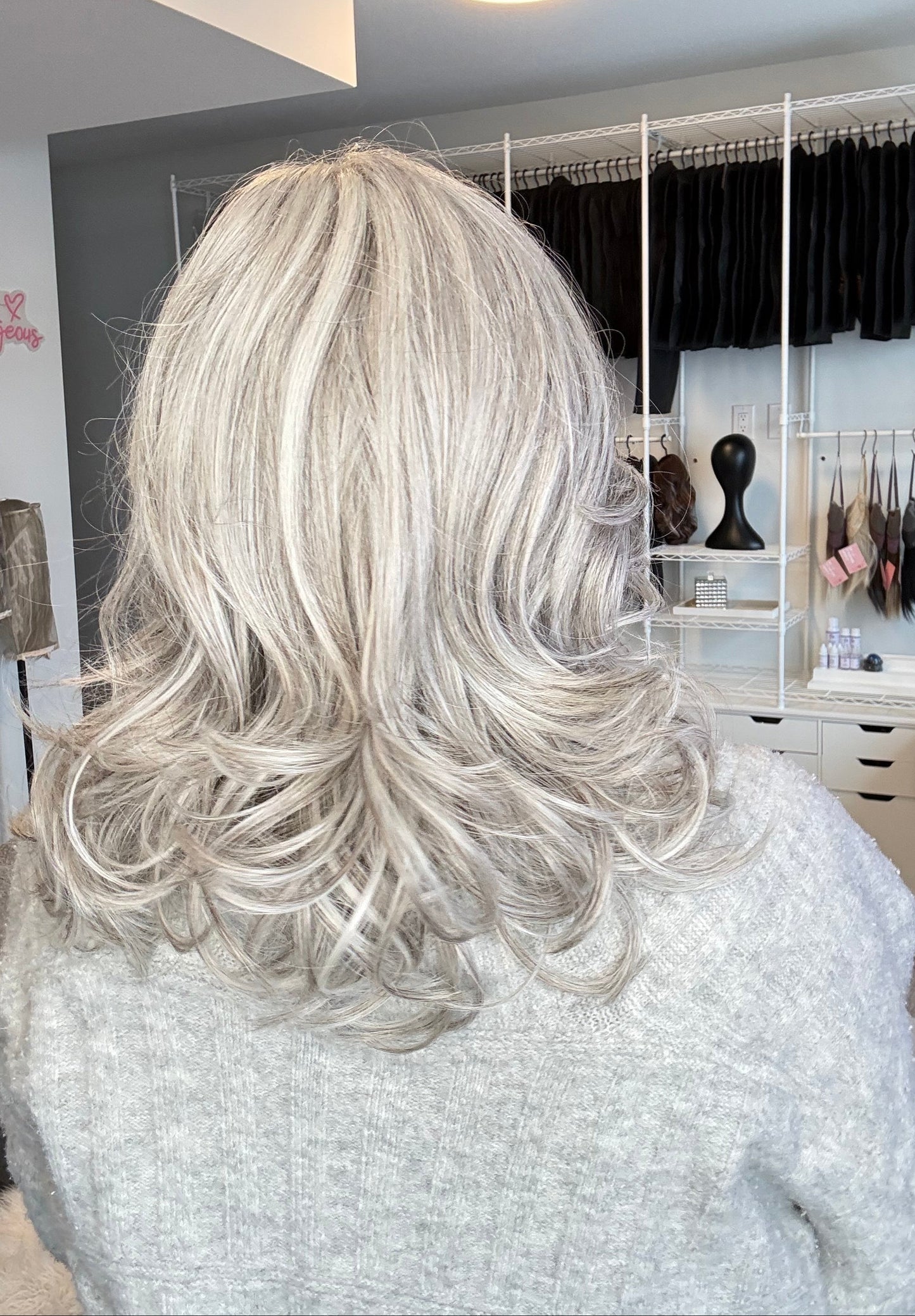 Silver hair extensions on a white surface with a blurred background