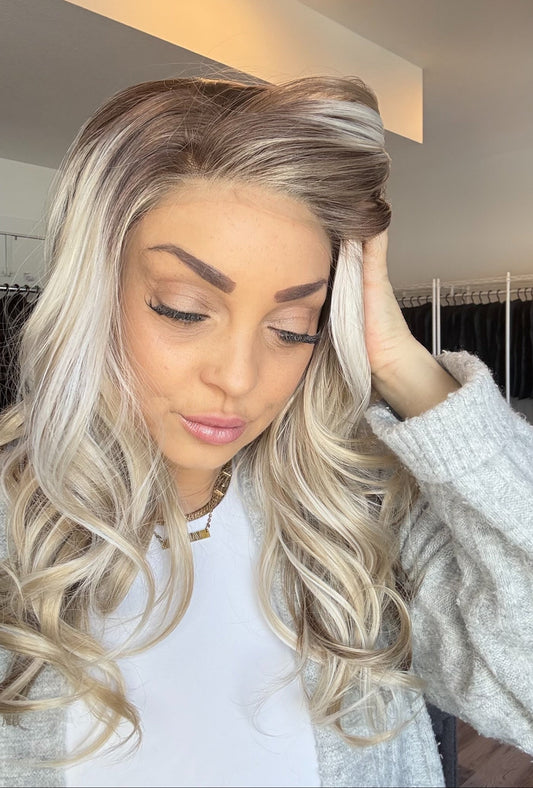 Woman with long, wavy blonde hair in a clothing store.