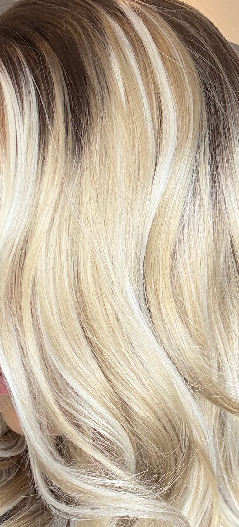 Person with long, wavy blonde hair in a salon setting