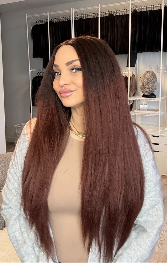 Woman with a long brown wig in a hair product store.