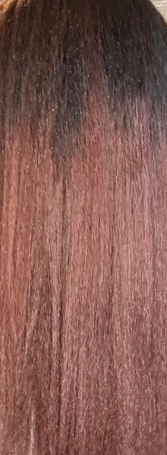Close-up of a person with long, straight hair in a salon setting.