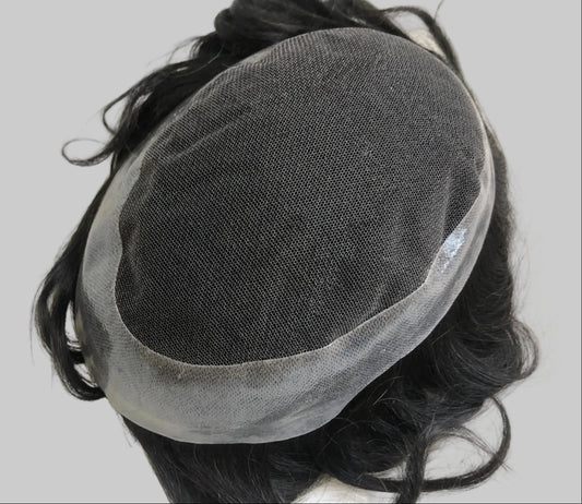 Black hair wig with a transparent mesh cap on a white textured surface