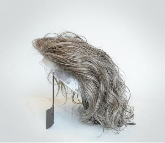 Large clump of gray hair on a stand with a blurred indoor background