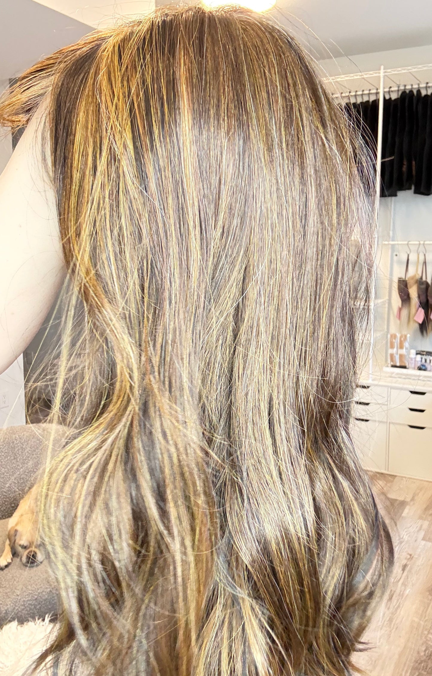 Close-up of a person with long, wavy hair in a salon setting.