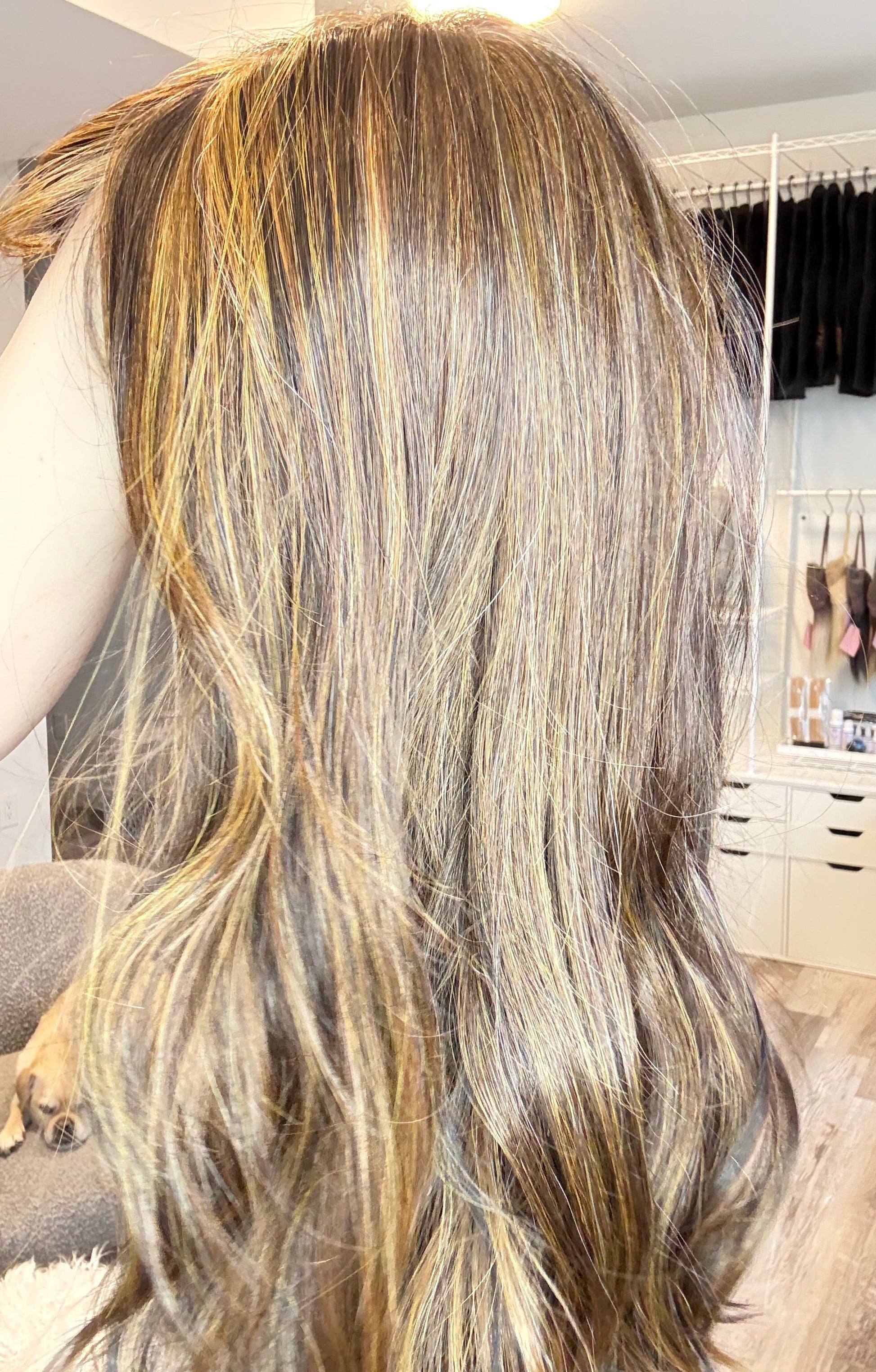 Close-up of a person with long, wavy hair in a salon setting.
