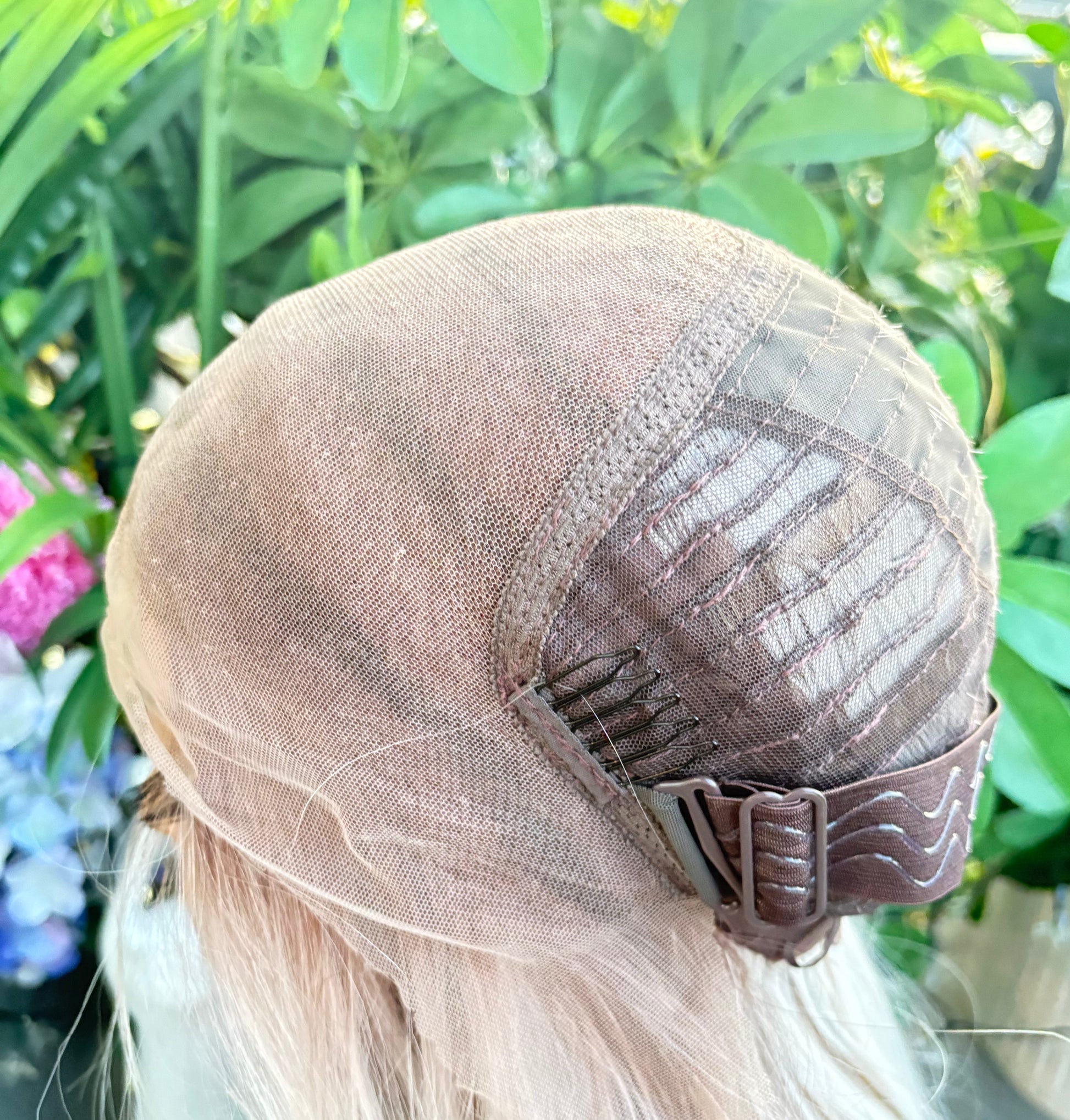 Close-up of a hair wig with a green leafy background