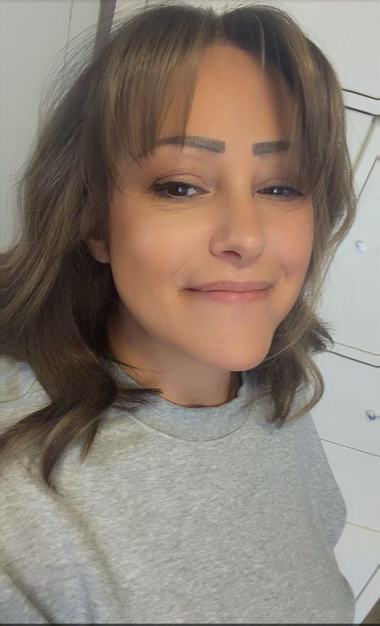 Person with a neutral expression on a phone screen