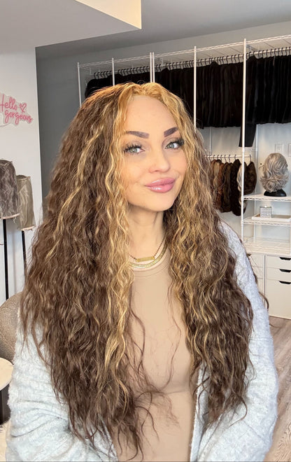 Person with long, wavy hair in a wig store setting