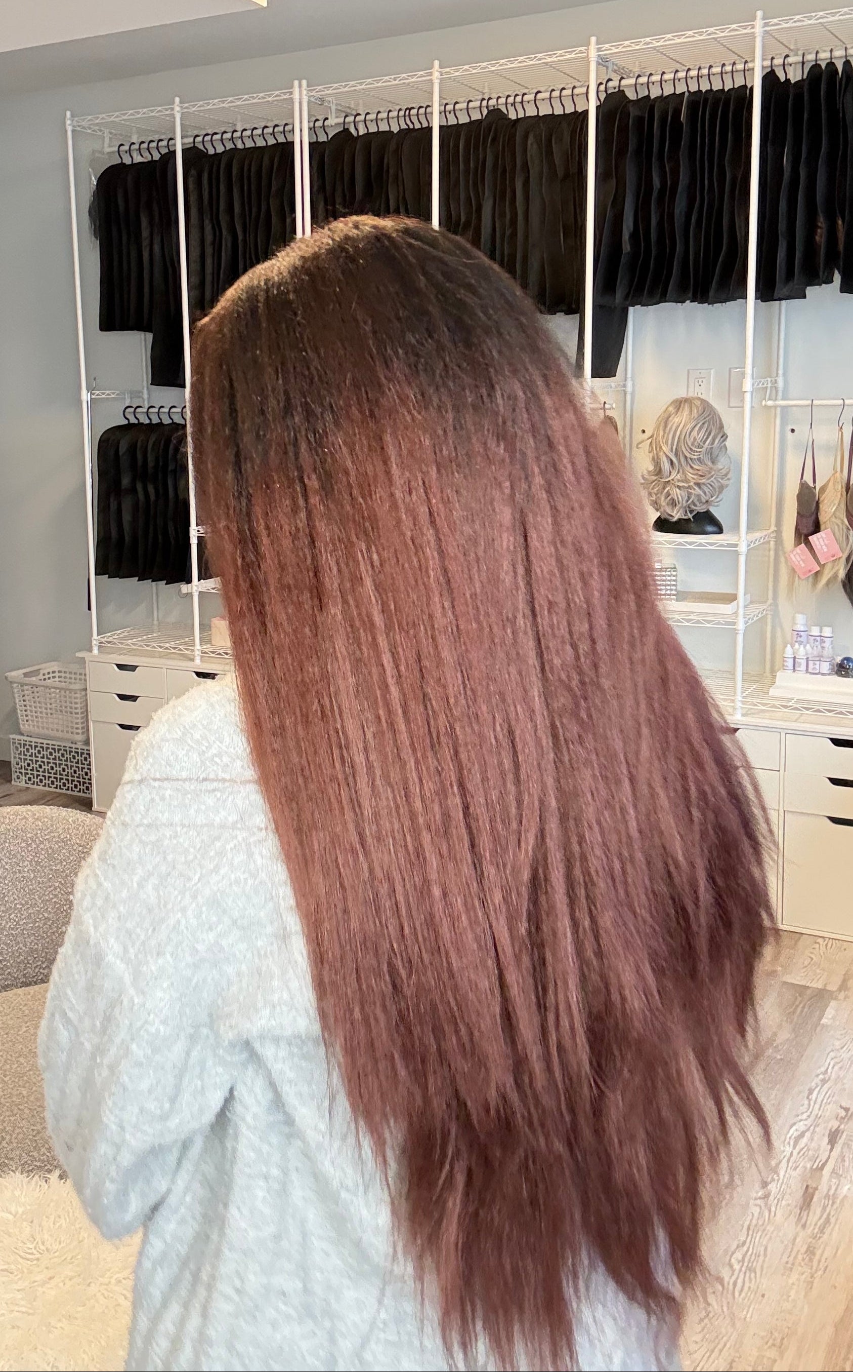 Person with long brown hair in a salon setting