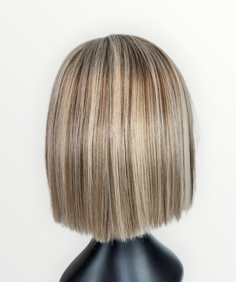 Blonde bob wig on a mannequin head against a white background
