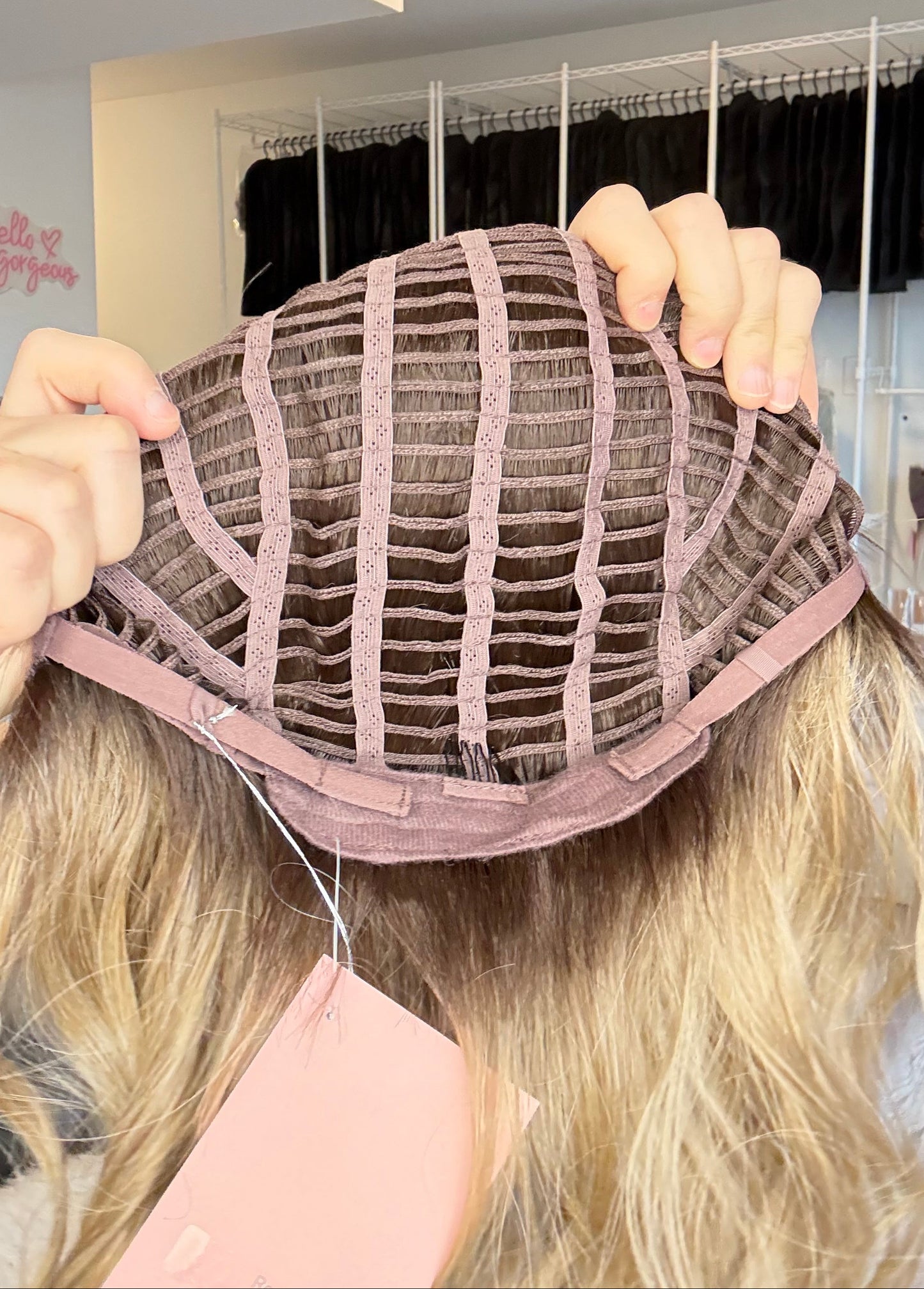 Person holding a wig with a mirror reflection in the background