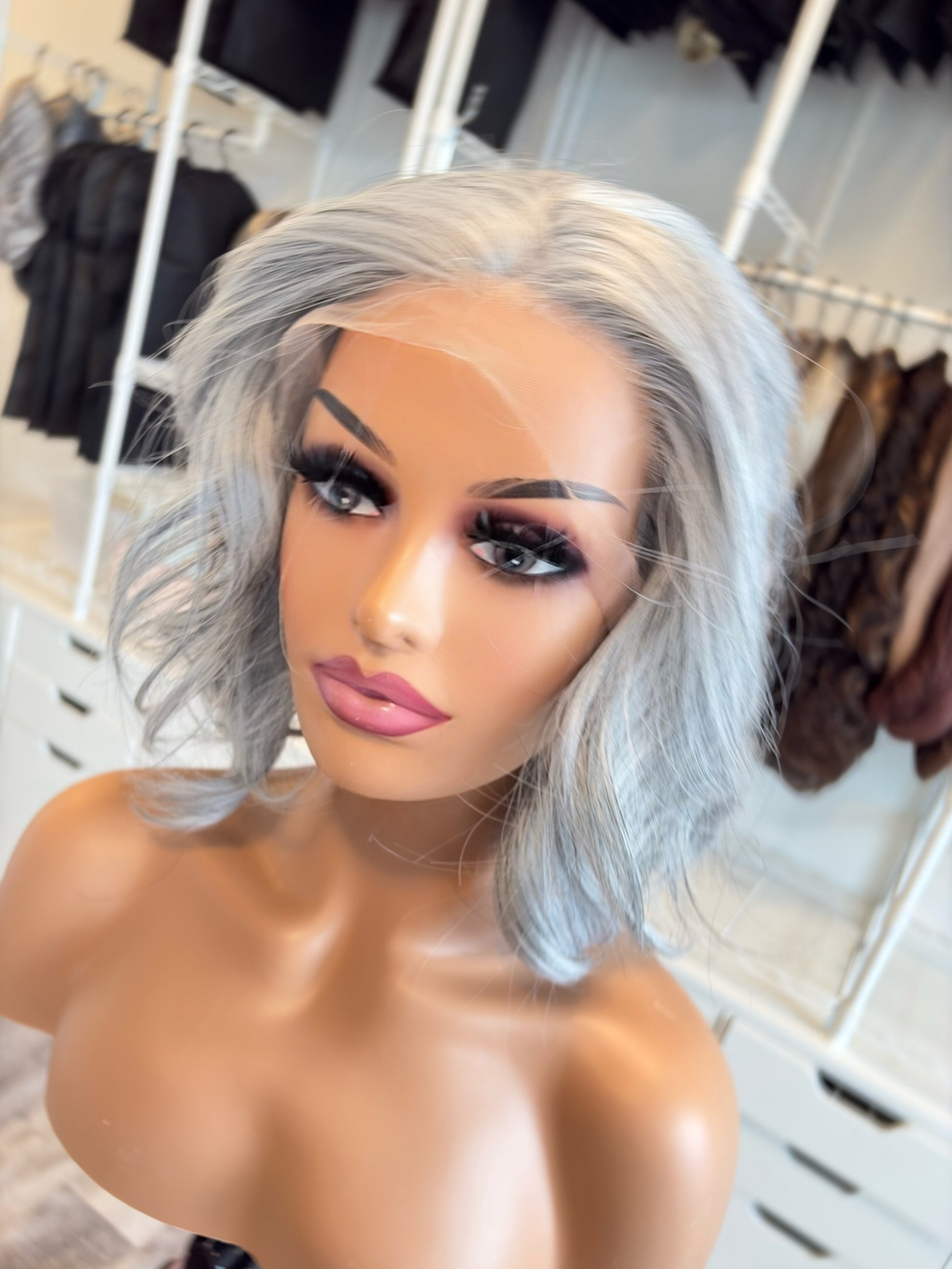 Mannequin head with a silver wig in a clothing store setting