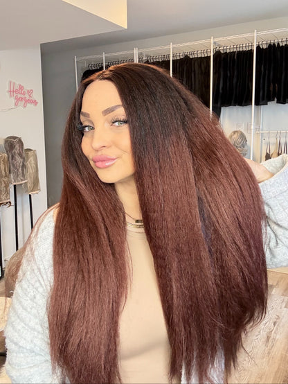 Person with long brown wig in a store setting