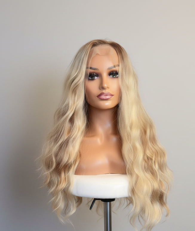 Blonde wig on a mannequin head against a white background