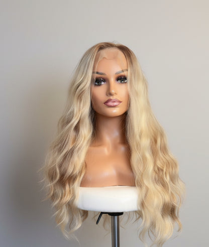 Blonde wig on a mannequin head against a white background