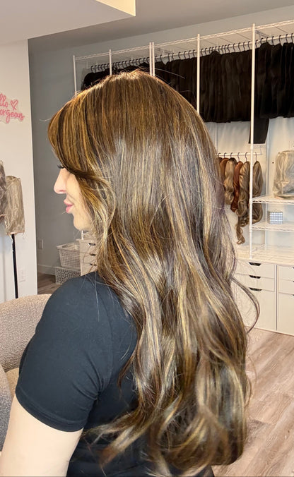 Person with long, wavy hair in a salon setting