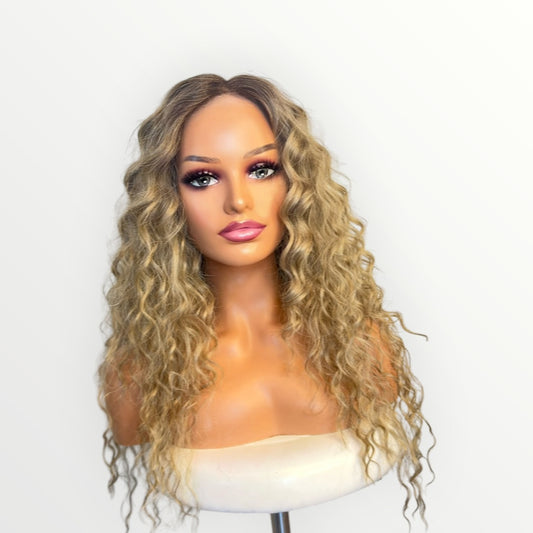 Blonde wig on a mannequin head against a white background