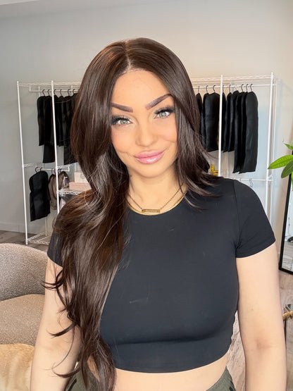 Woman wearing a black crop top in a room with clothing racks and decor.