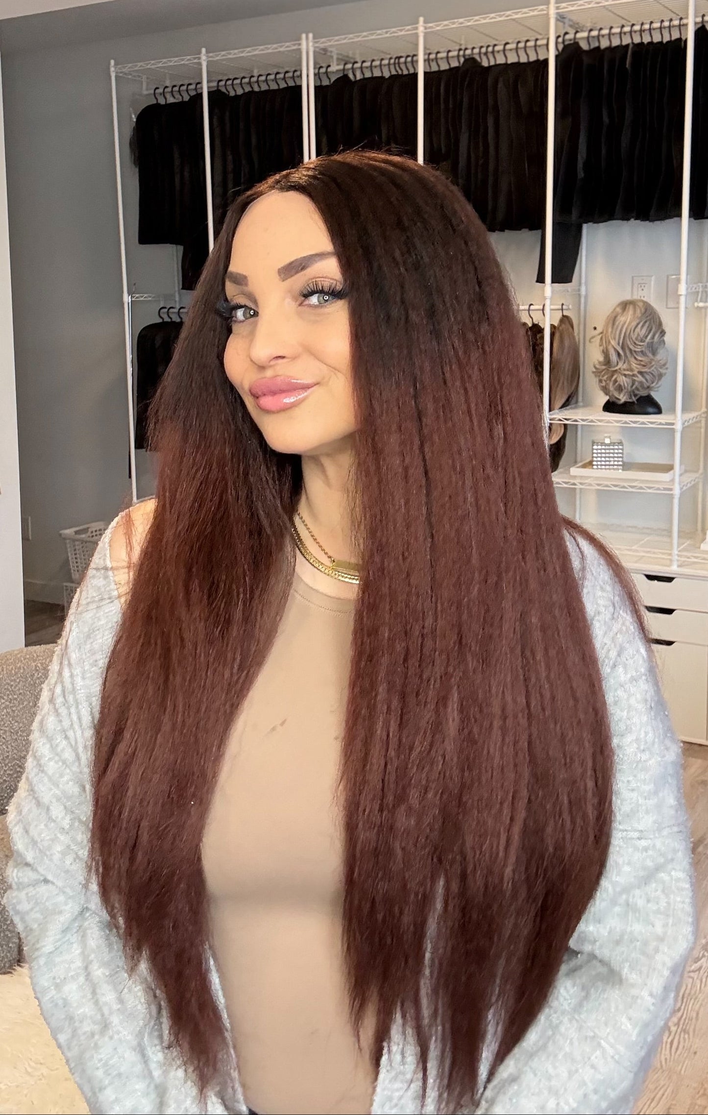 Woman with a long brown wig in a hair product store.