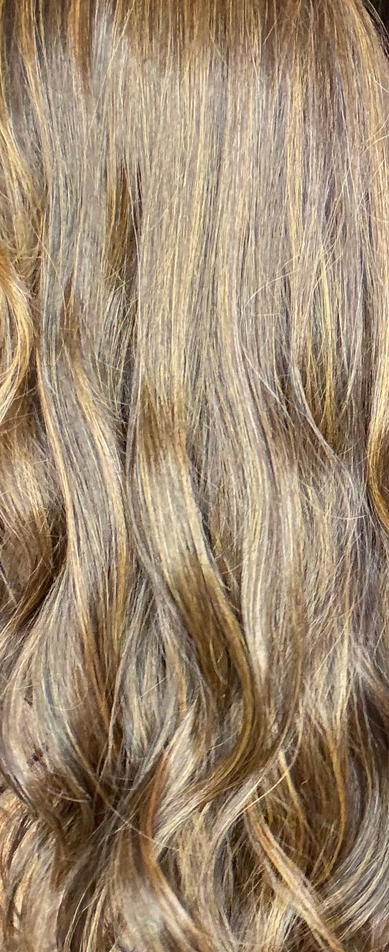 Person with long, wavy hair styled in a salon setting
