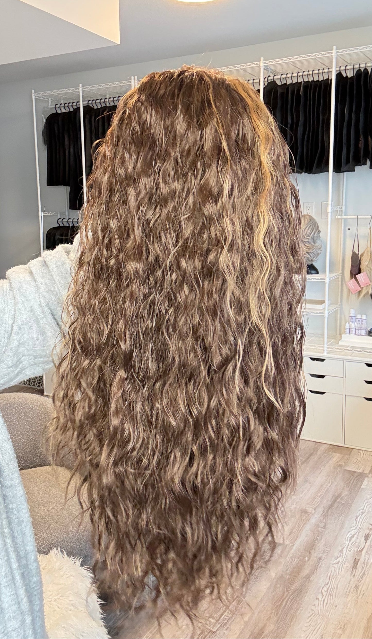 Person with long, wavy hair in a salon setting