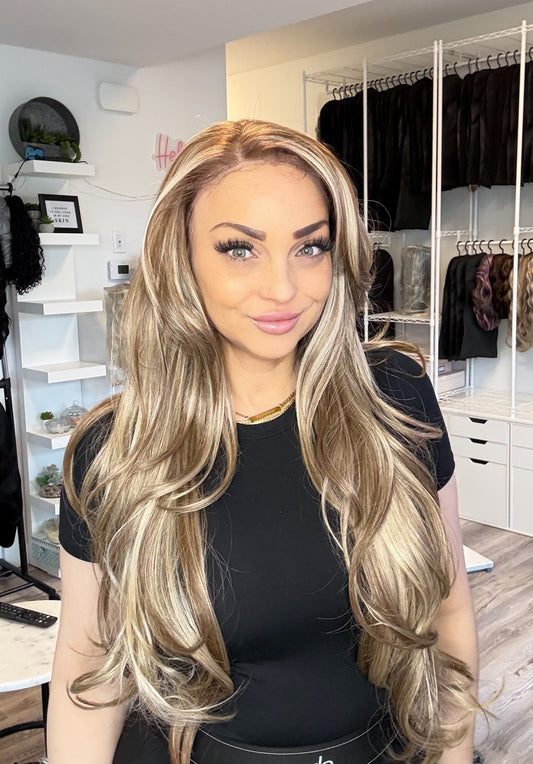 Person wearing a blonde wig in a store setting with hair products in the background