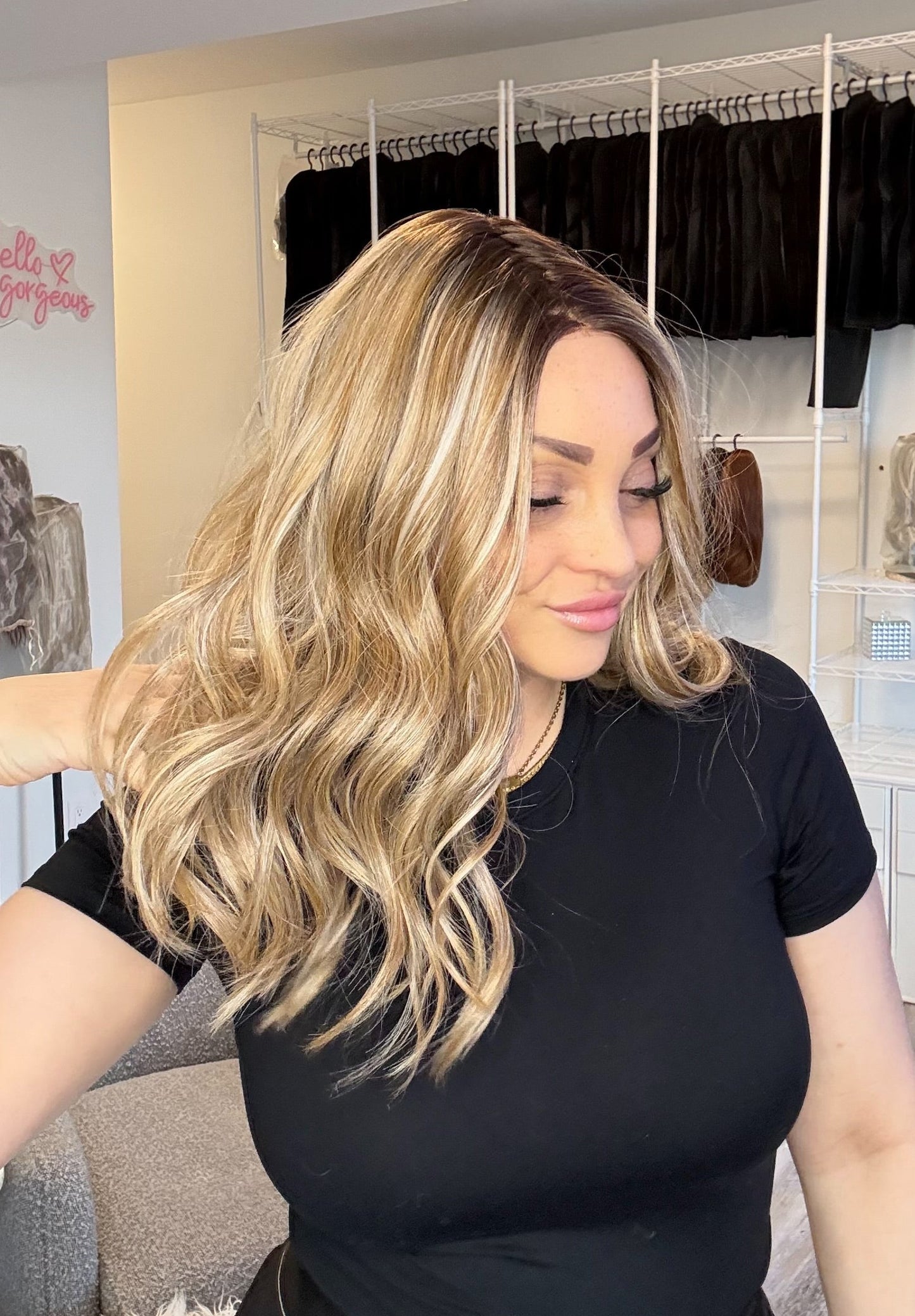 Woman with styled hair in a room with clothing racks and shelves.