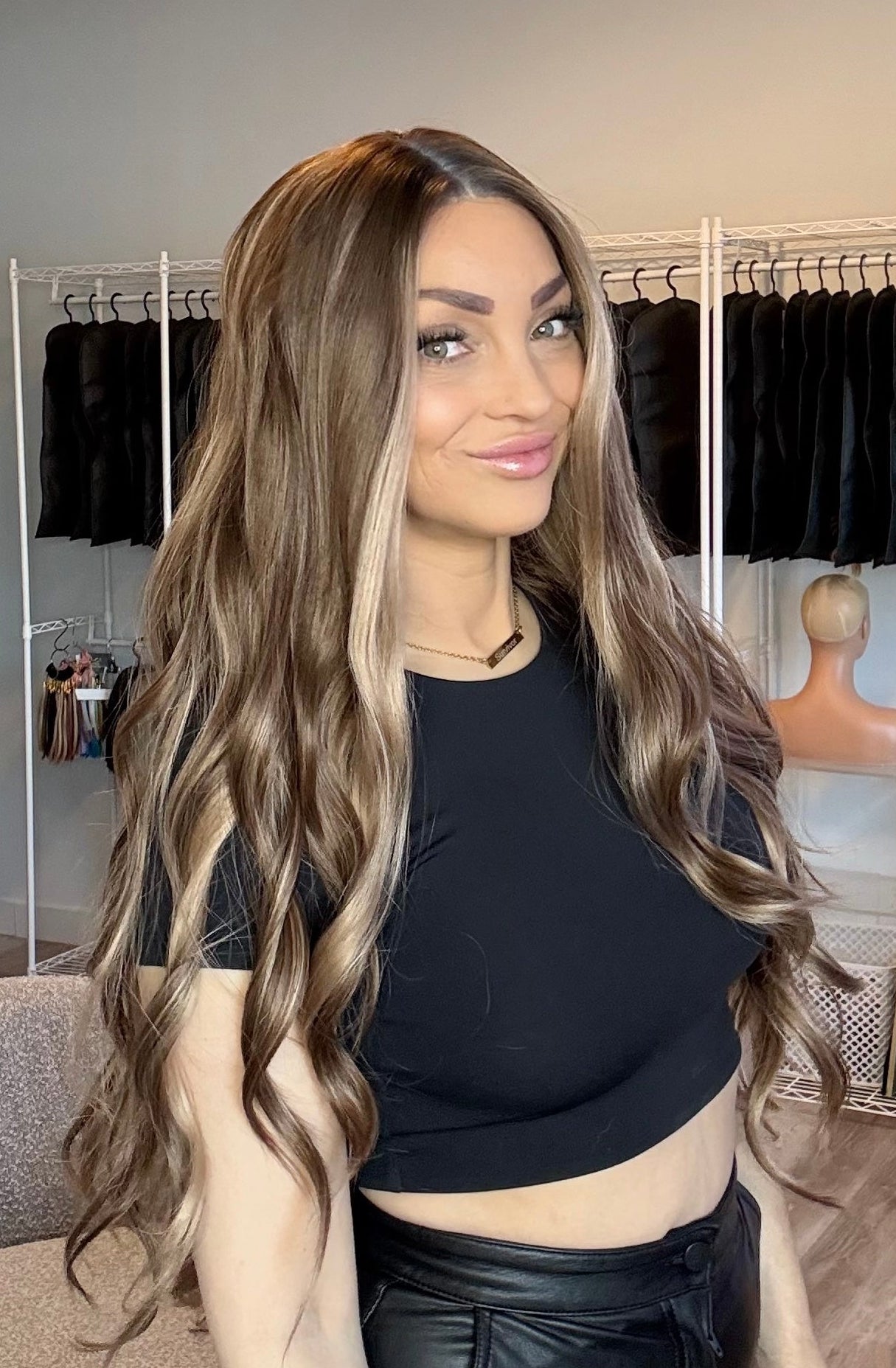 Woman with long, wavy hair styled in a salon setting.