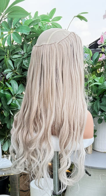 Mannequin head with blonde hair extensions on a floral and decorative background