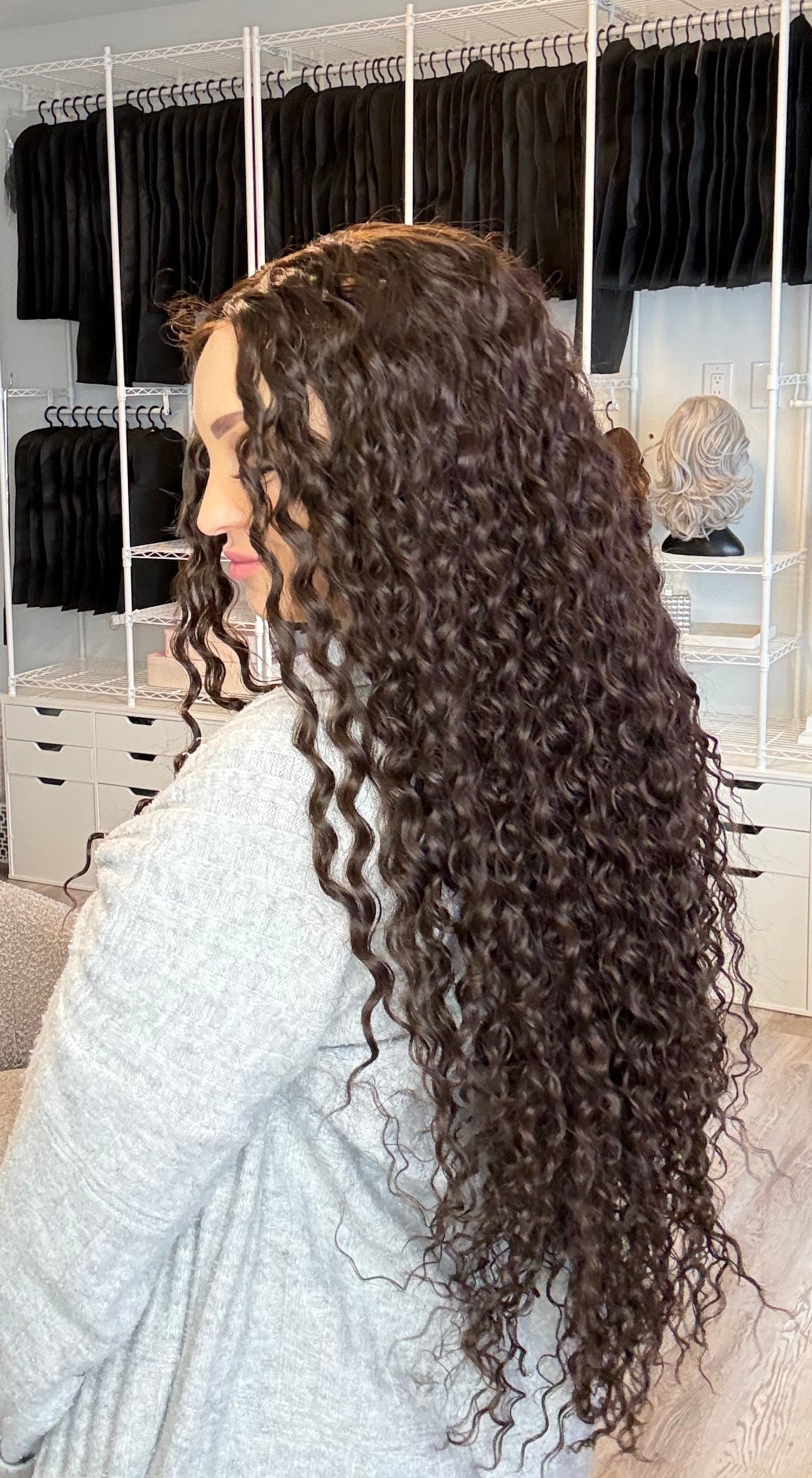 Person with long, curly hair in a salon setting