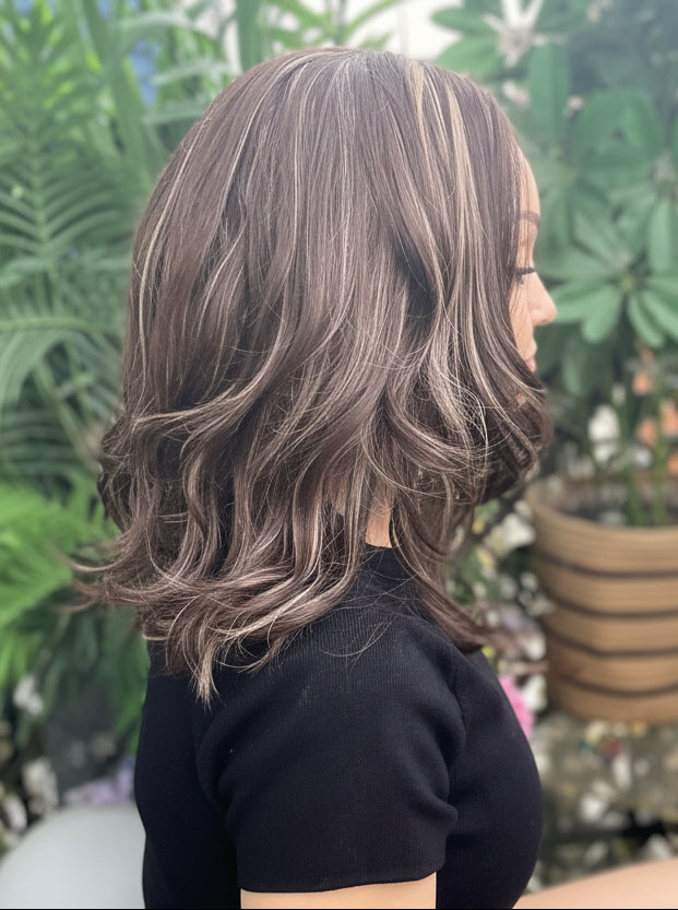 Person sitting on a bench with plants in the background