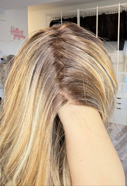 Person with long, styled hair in a salon setting