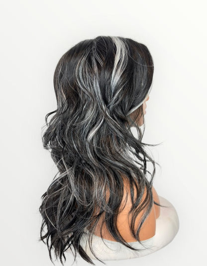 Black and gray wavy wig on a mannequin head against a white background