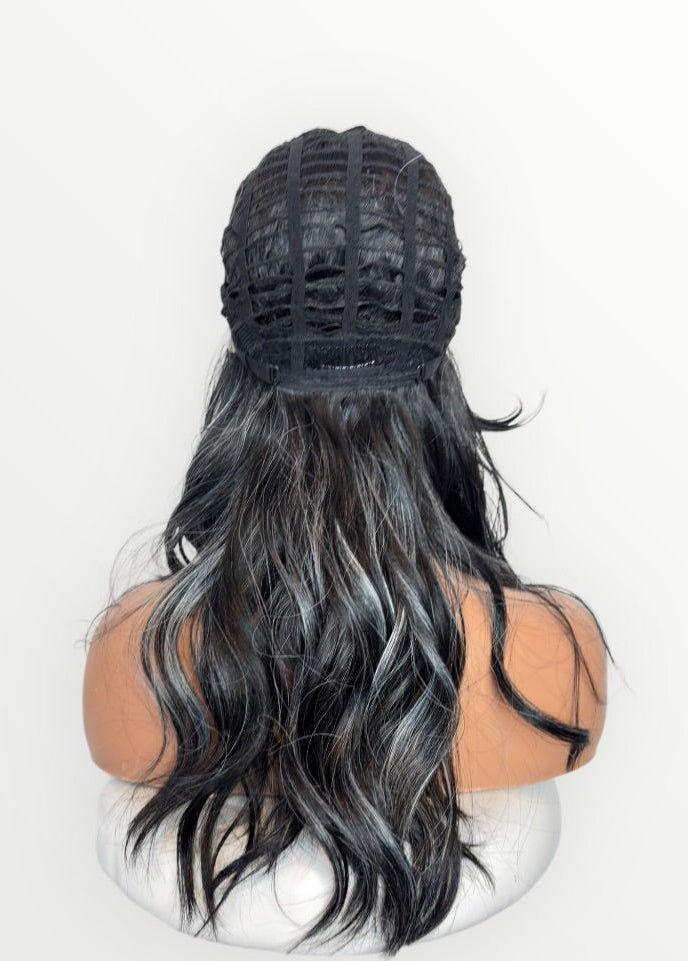 Person with long black and gray hair wearing a black lace front wig cap on a white background