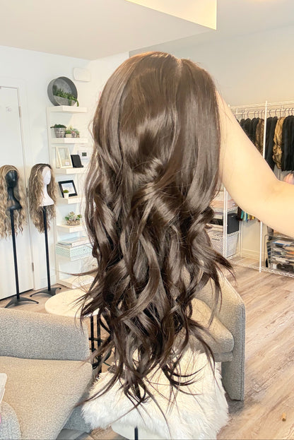Person with long, wavy hair in a salon setting