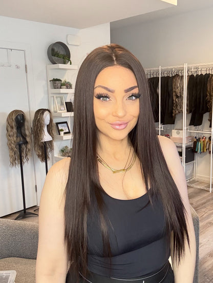 Person wearing a wig in a room with wig displays in the background