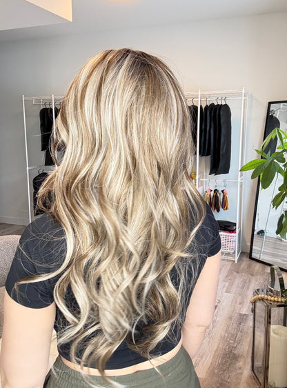 Person with long blonde hair in a salon setting