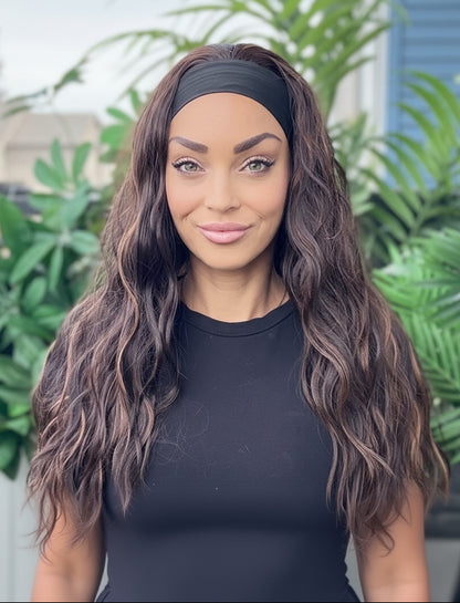 Woman wearing a black headband and top in front of green plants