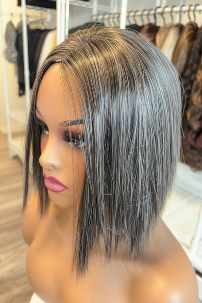 Mannequin head with a short, straight wig in a hair salon setting.