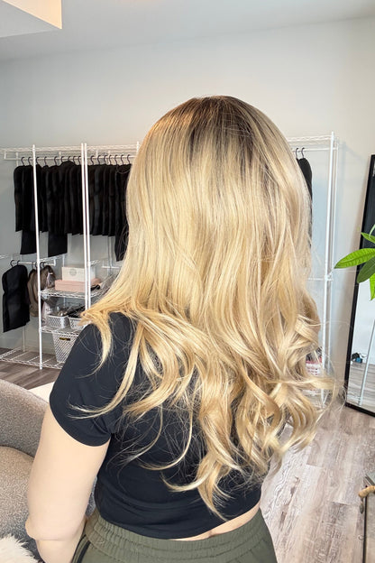 Person with styled blonde hair in a salon setting