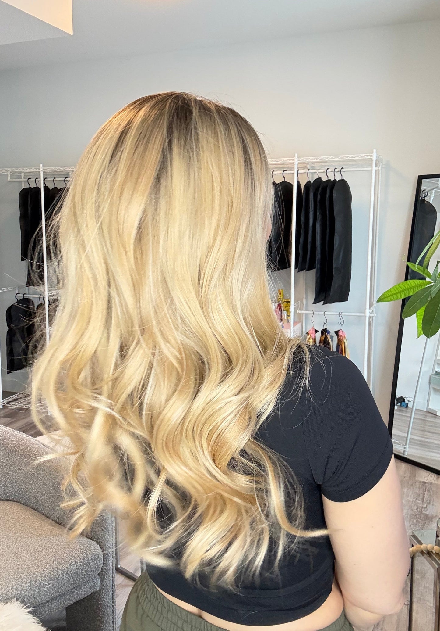 Person with long blonde hair styled in a salon setting