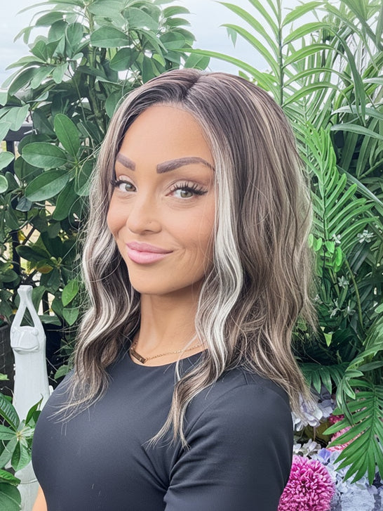 Woman with styled hair in front of green foliage