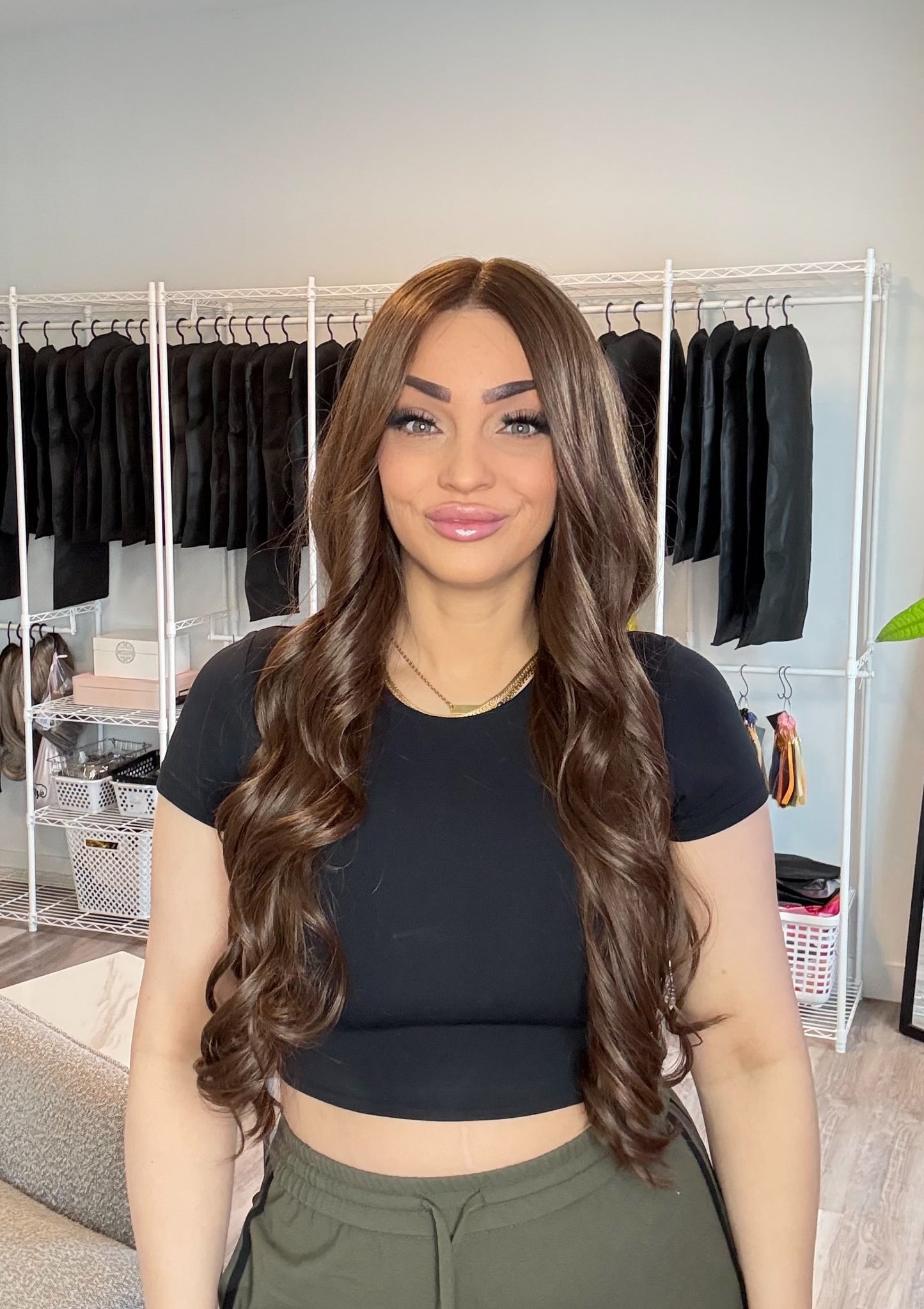 Woman standing in a room with clothing racks in the background