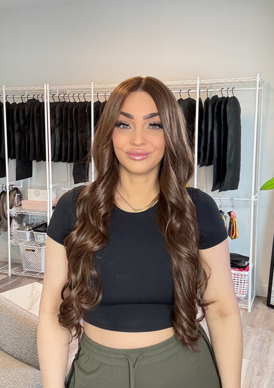 Woman standing in a room with clothing racks in the background