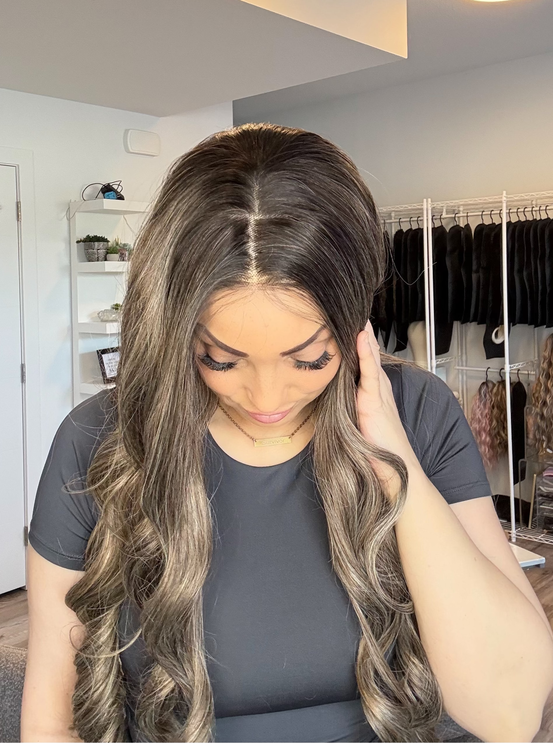 Woman with long, wavy hair in a room with a closet and shelves.