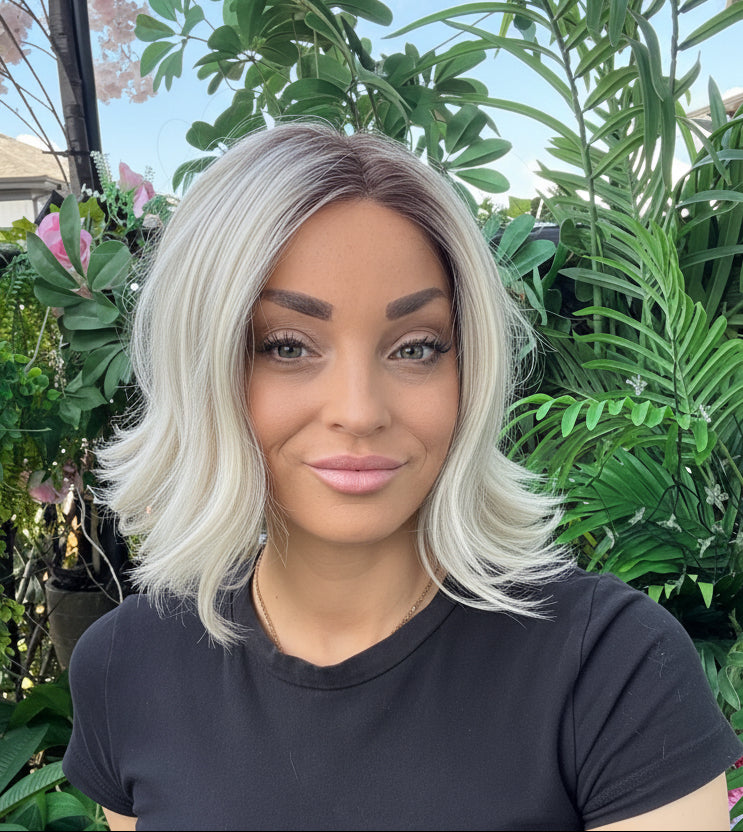 Woman with a black shirt standing in front of green plants
