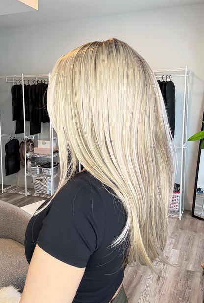 Person with long blonde hair in a salon setting
